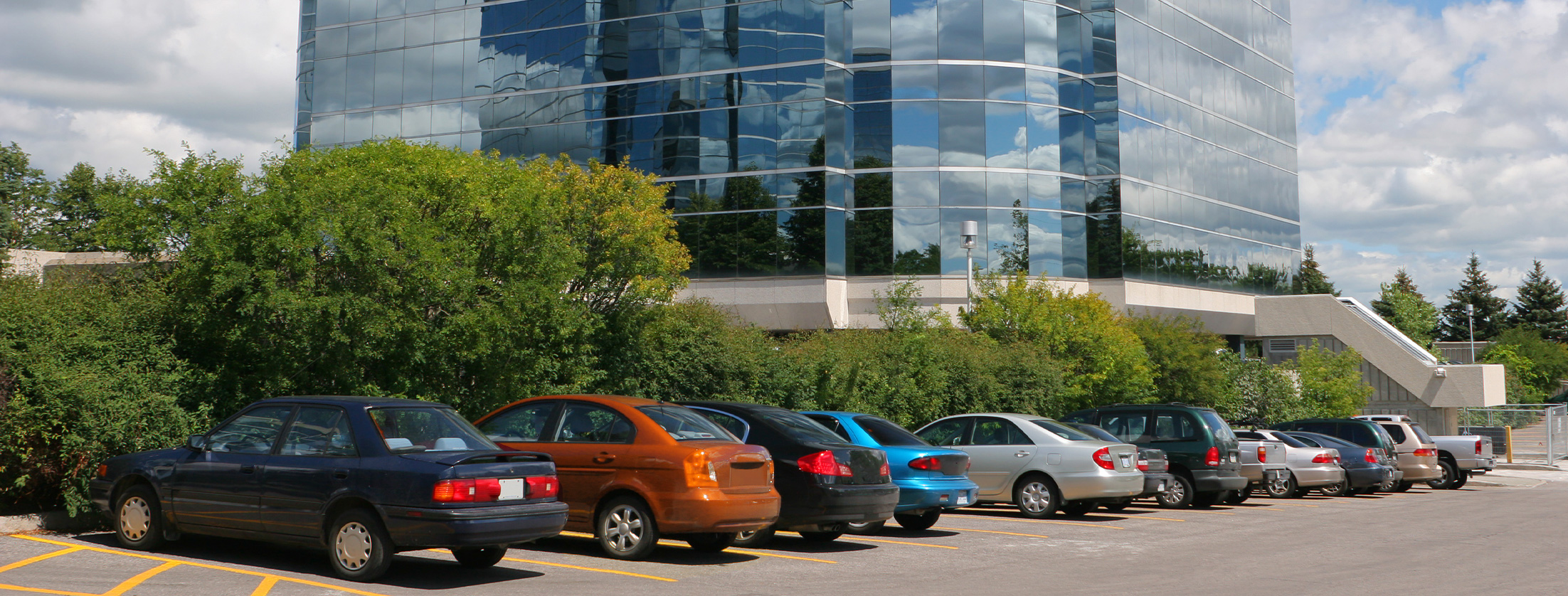 Application of a parking lot with parked cars and an office building in the background
